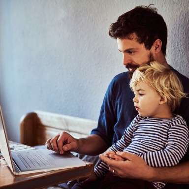 Vader met kind achter de laptop