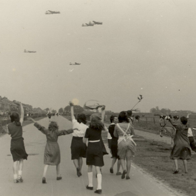 Op de Rijksweg bij de Velserbroekstraat begroet de bevolking de vliegtuigen met voedsel, ziende naar het noorden. Noord-Hollands Archief Kennmerland,NL-HlmNHA_54014011. 