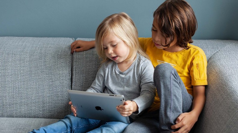 foto van 2 kinderen op de bank en tablet